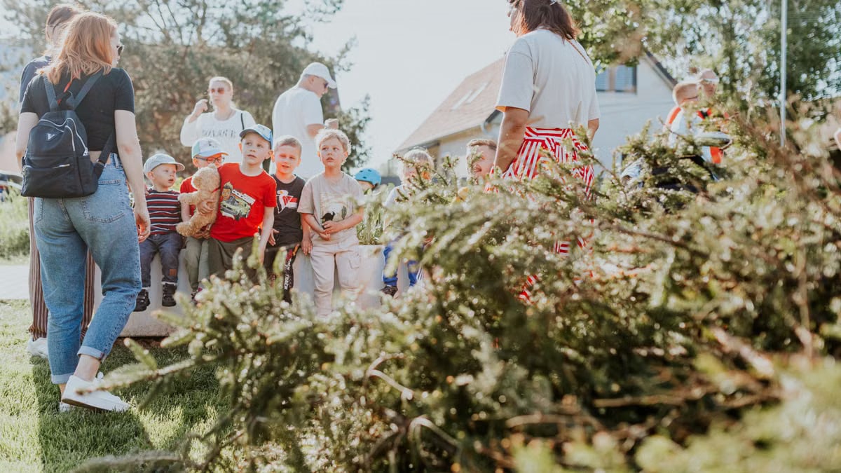 Children and adults participating in an outdoor educational activity surrounded by nature.